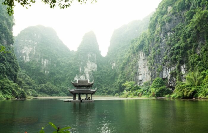 Picture of a small hut in the middle of the lake surrounded by mountains in Ninh Binh